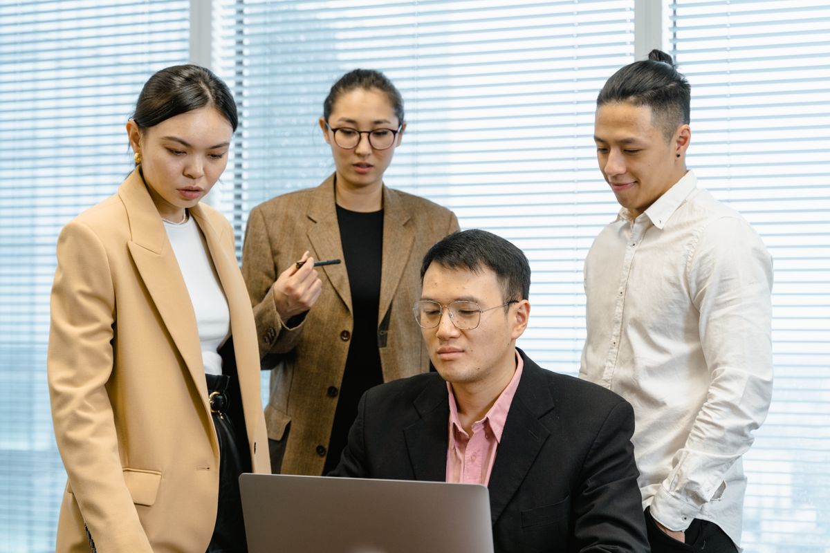 ノートPCを囲んで実装方針を話し合うプロジェクトチーム