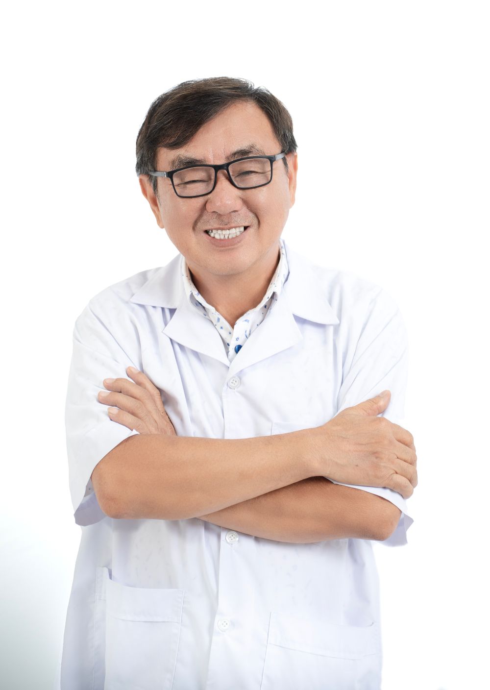 白衣姿で腕を組み微笑む院長